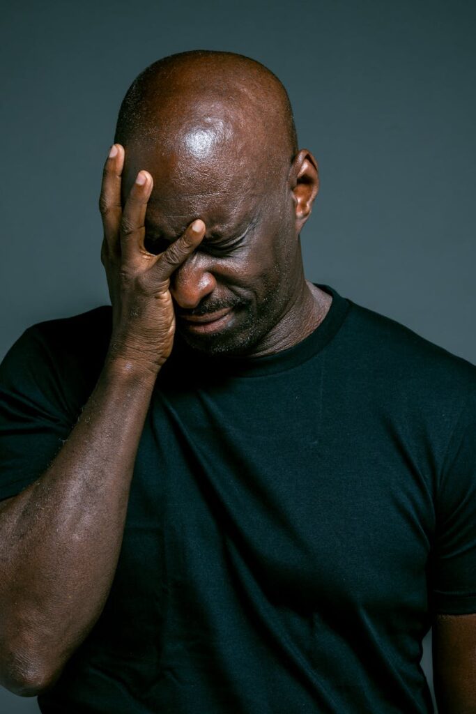 Afroamerykański mężczyzna z bólem głowy, ilustrujący frustrację użytkowników